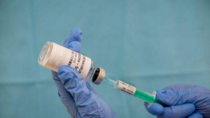 Infectious doctor fills injection syringe with CO-VID 19 vaccine - concept, for prevention, immunization and treatment for new corona virus infection(COVID-19,novel coronavirus disease 2019)