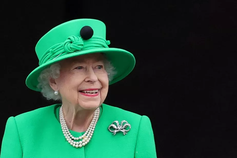 99468889-topshot-britains-queen-elizabeth-ii-smiles-to-the-crowd-from-buckingham-palace-balcony-a